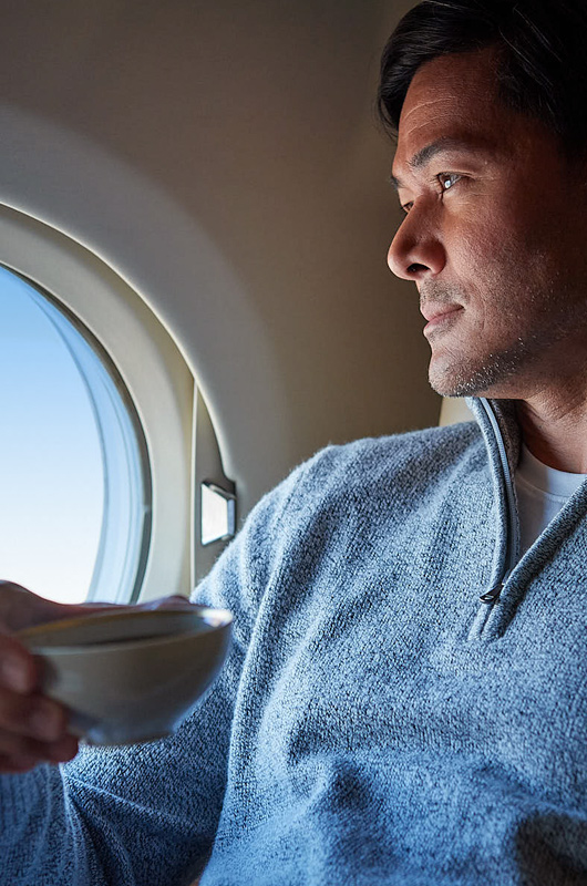 man sipping coffee on an airplane