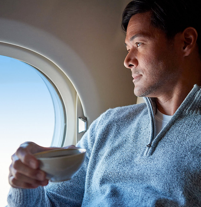 man sipping coffee on an airplane