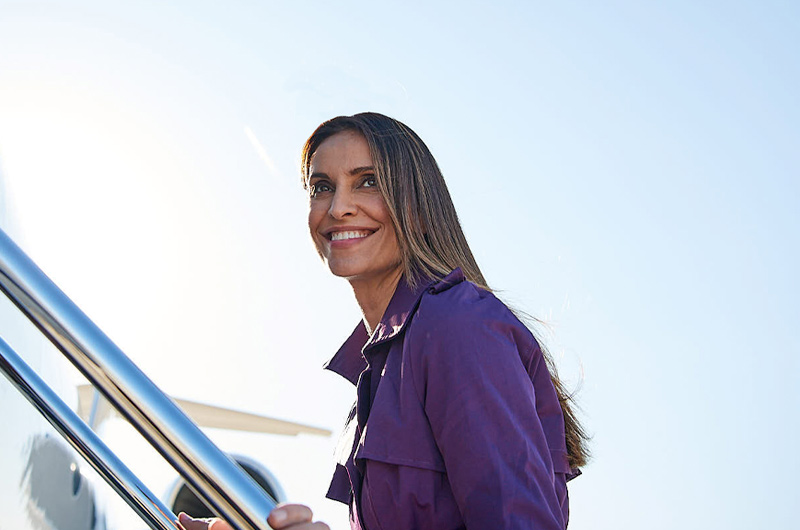 woman smiling as she walks up stairs to jet